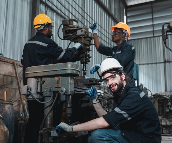 Industrial engineers inspect and perform maintenance on the machines at factory machines.